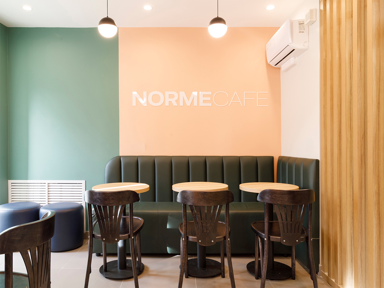 Посадочные места и логотип Norme Cafe на стене кафе Крутицкий